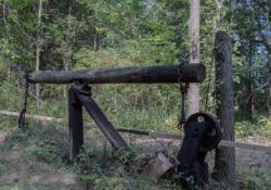 Just as it would have appeared in the 1860s, the pumpjack continues to pump the oil well surrounded by woods.